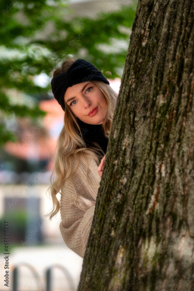 Pretty face young girl looking from behind a tree Pretty face young girl looking from behind a tree