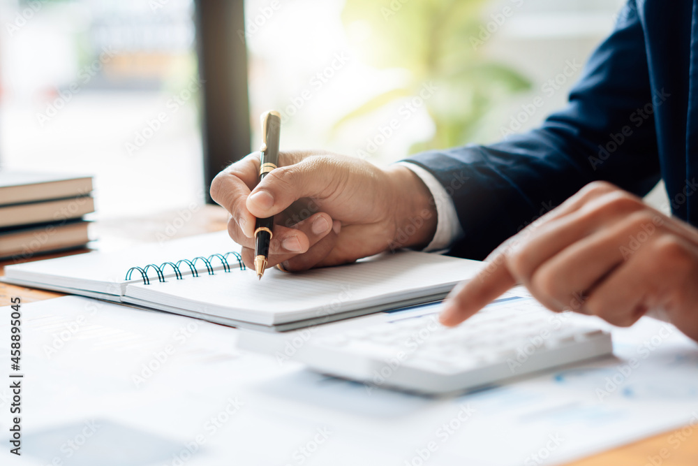 Close up Businessman and partner using calculator and laptop for calaulating finance, tax, accounting, statistics and analytic research concept Close up Businessman and partner using calculator and laptop for calaulating finance, tax, accounting, statistics and analytic research concept