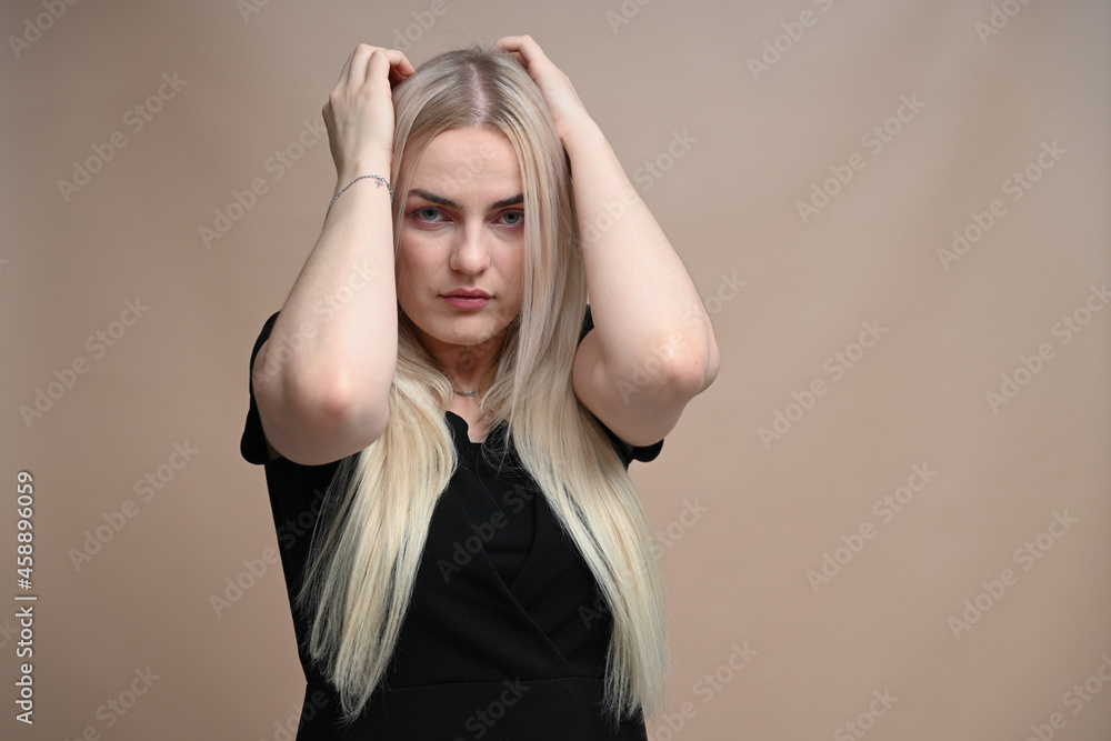 Frightened girl on a beige background looking at the camera Frightened girl on a beige background looking at the camera