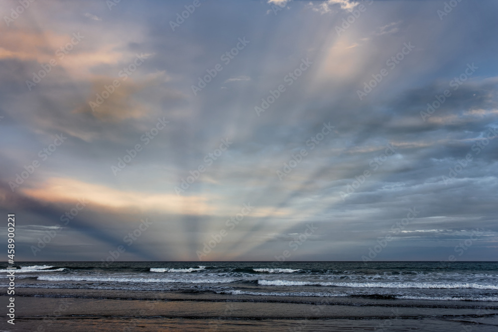 Fototapeta premium Sunbeams at Woodend Beach, south island, New Zealand.