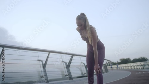 Woman athlete limping, touching sore knee, injury during jogging, sports trauma