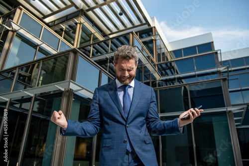 Wallpaper Mural mature business man in panic holding phone outdoor, bankruptcy Torontodigital.ca