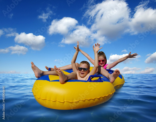 Boy and girl on inflatable float in blue sea water.