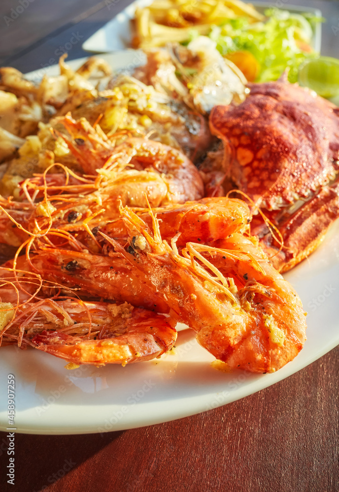 Grilled seafood platter with crab, fish and prawns in garlic sauce, selective focus. Grilled seafood platter with crab, fish and prawns in garlic sauce, selective focus.