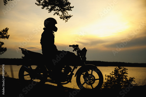 silhouette of a girl on a motorcycle at sunset