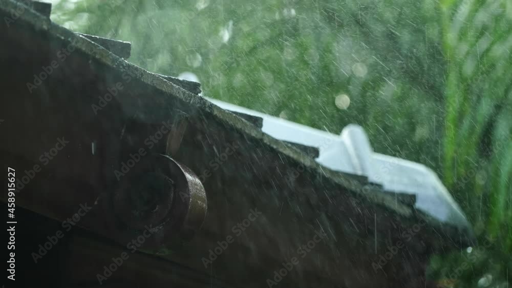 Close-up motion of heavy rain drop on the roof gutters with greenery tree. nice view for relaxing eyes. Close-up motion of heavy rain drop on the roof gutters with greenery tree. nice view for relaxing eyes.