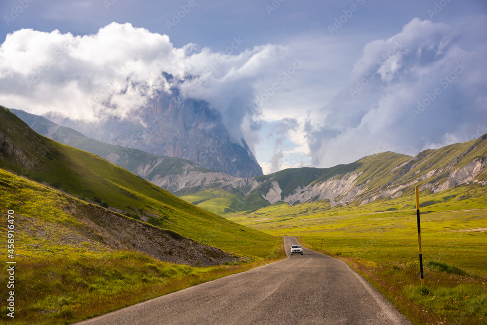 A car driving on a mountain road in summer