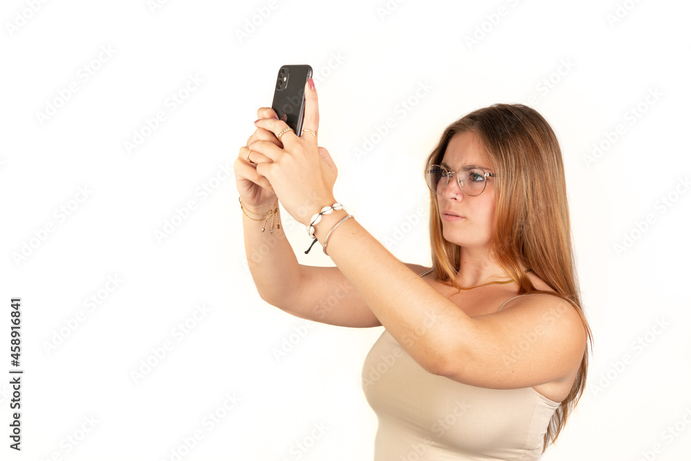 Young woman without signal holding up his mobile phone. White background. 20-22 years old. White European Woman. Young woman without signal holding up his mobile phone. White background. 20-22 years old. White European Woman.