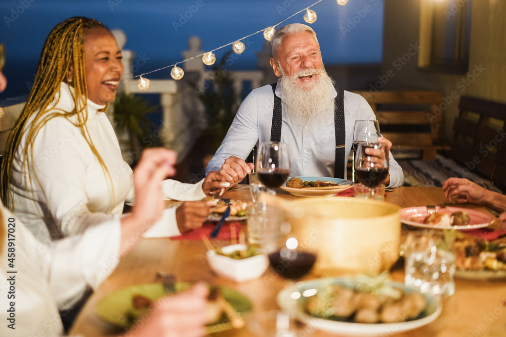 Senior people having fun at patio dinner party - Focus on hipster male face