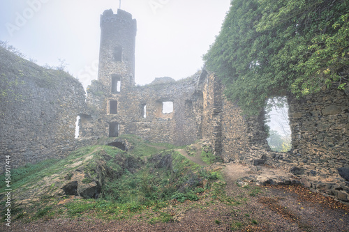 View of part of the Ardeck castle ruins near Holzheim / Germany in autumn with fog  photo