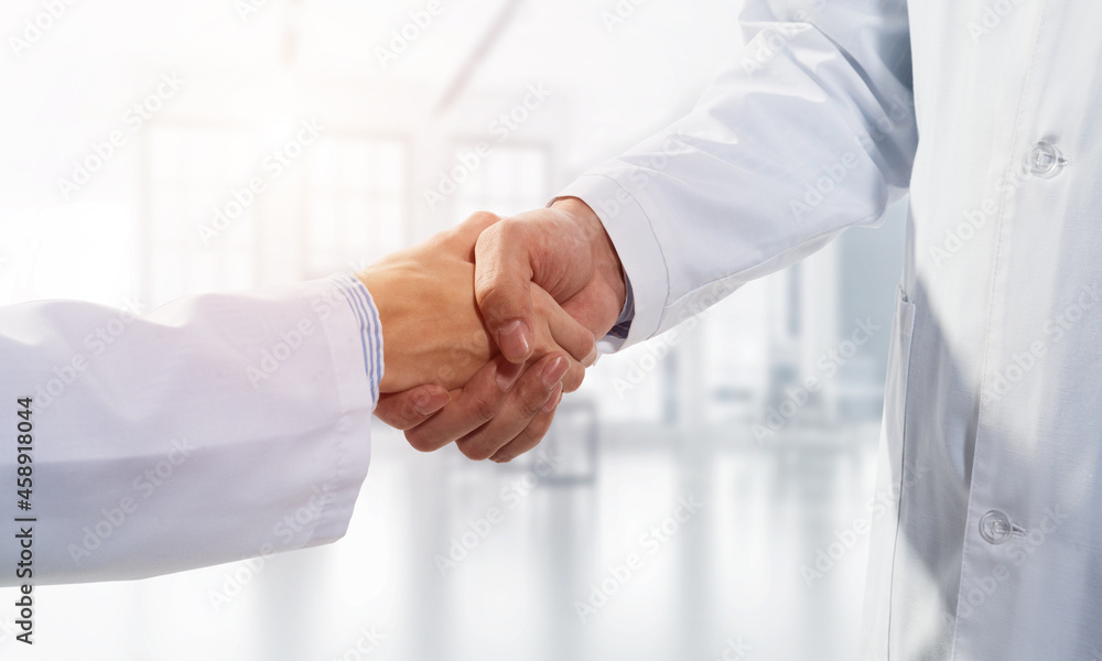 Close-up of the handshake between the two medics. Against the backdrop of the cityscape Close-up of the handshake between the two medics. Against the backdrop of the cityscape