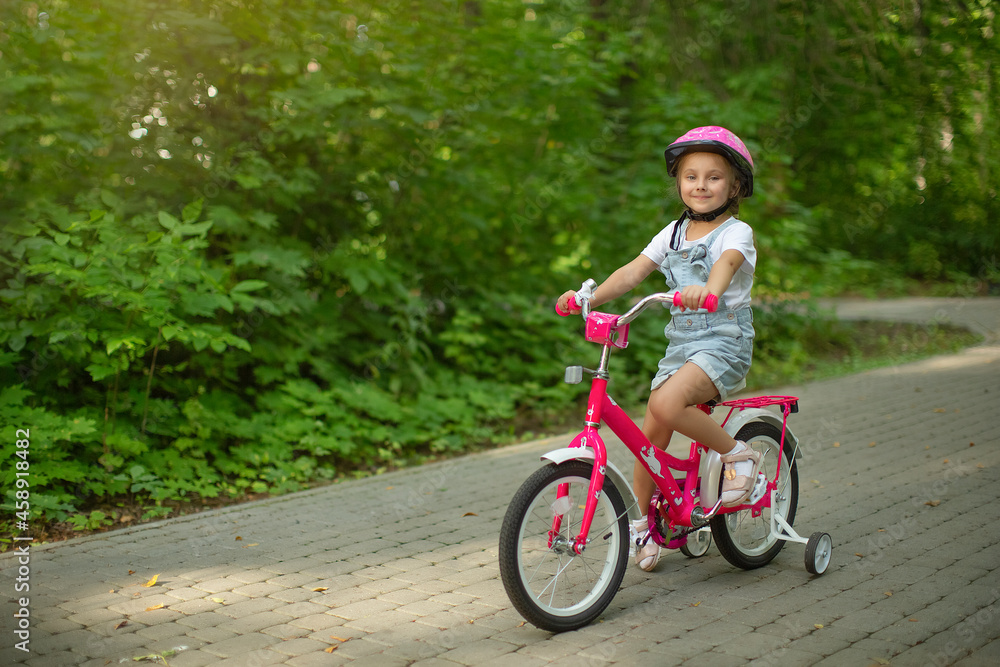 happy cheerful child girl riding a bike in Park in the nature happy cheerful child girl riding a bike in Park in the nature