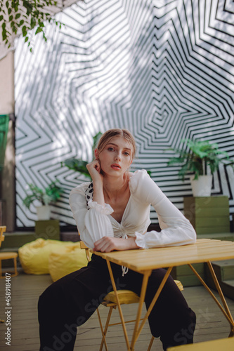 a beautiful girl in a white shirt walks around the city, a model girl in the city