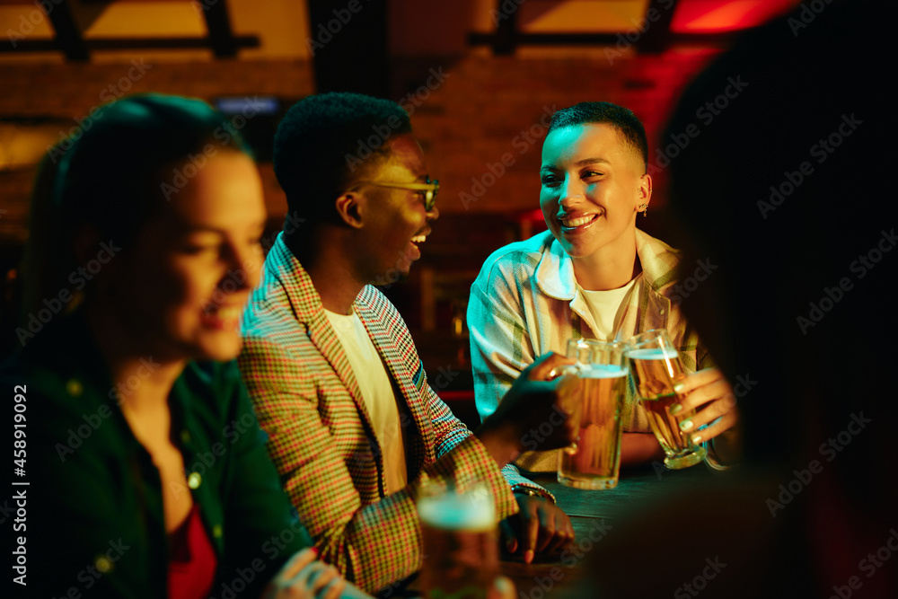 Happy African American couple toasting with beer in a pub. Happy African American couple toasting with beer in a pub.