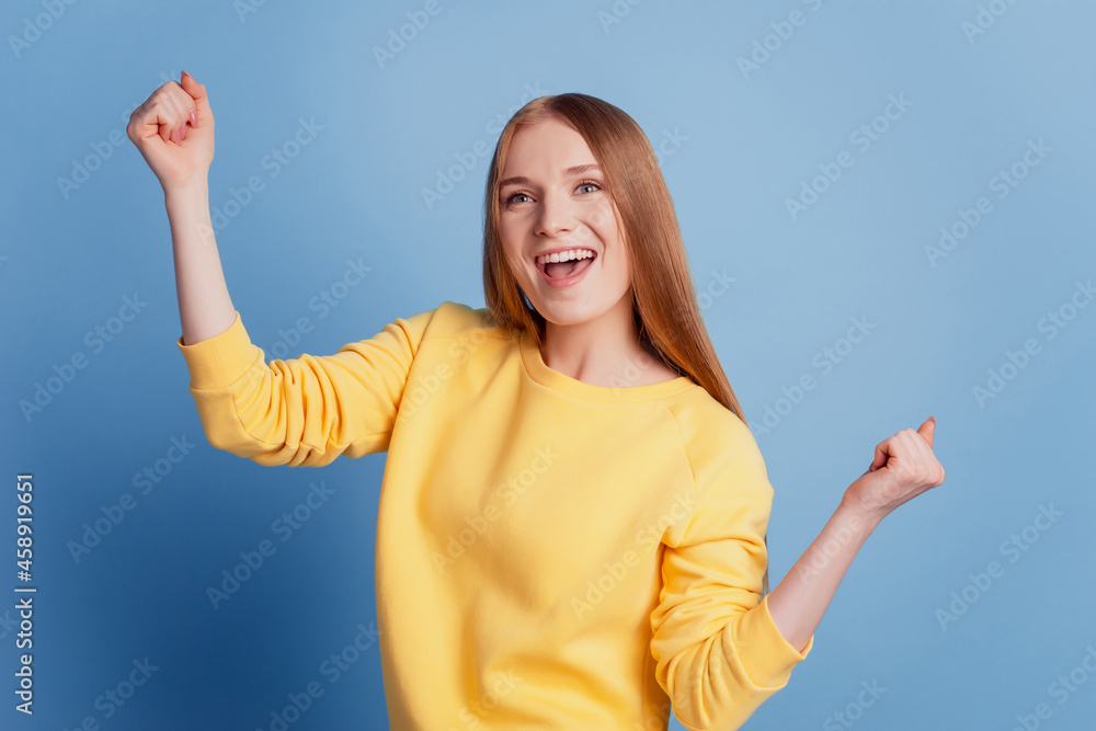 Portrait of excited winner lady raise fists open mouth celebrate victory on blue background Portrait of excited winner lady raise fists open mouth celebrate victory on blue background