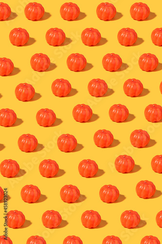 Pumpkin pattern in trendy bright lighting on yellow sunny background 