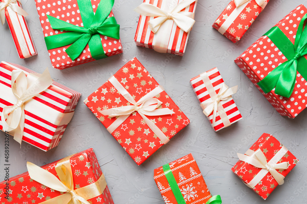 Fototapeta premium A lot of Christmas gift boxes in colored paper decorated on table, Top view close up. Many present New Year gift