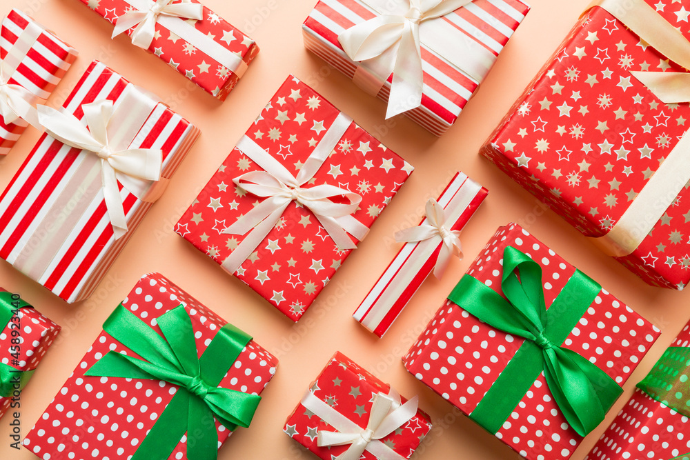 Fototapeta premium A lot of Christmas gift boxes in colored paper decorated on table, Top view close up. Many present New Year gift