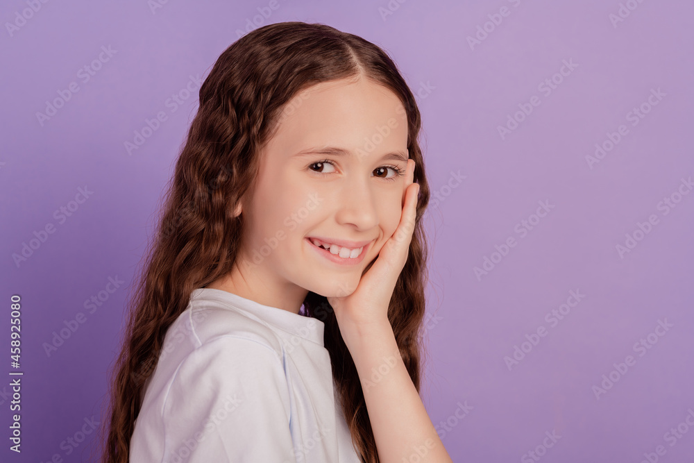 Portrait of charming lovely small girl palm cheek toothy beaming smile on purple background Portrait of charming lovely small girl palm cheek toothy beaming smile on purple background
