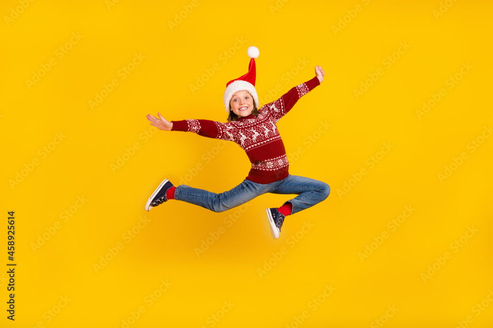 Full body photo of cheerful little happy girl jump up christmas sale isolated on yellow color background