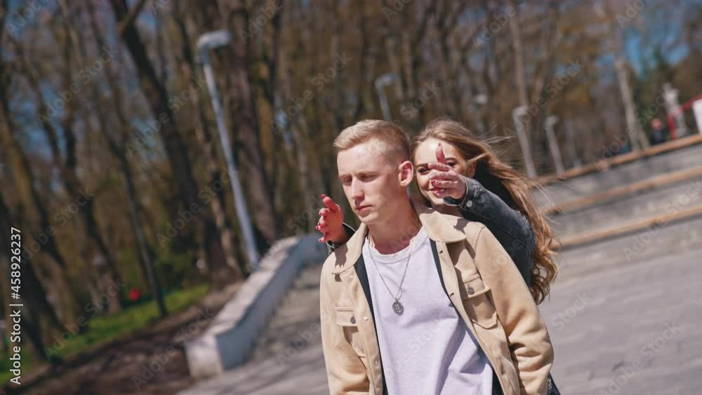 Guess who. Happy couple in love meeting in the park. Woman closed eyes of her boyfriend while standing behind him. Romantic date concept Guess who. Happy couple in love meeting in the park. Woman closed eyes of her boyfriend while standing behind him. Romantic date concept