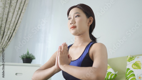asian woman yoga at home doing hand exercises with focus