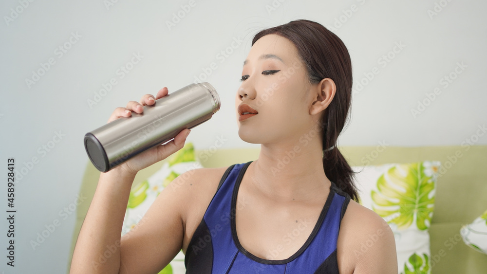 young woman who finished yoga drinking water in her bottle young woman who finished yoga drinking water in her bottle