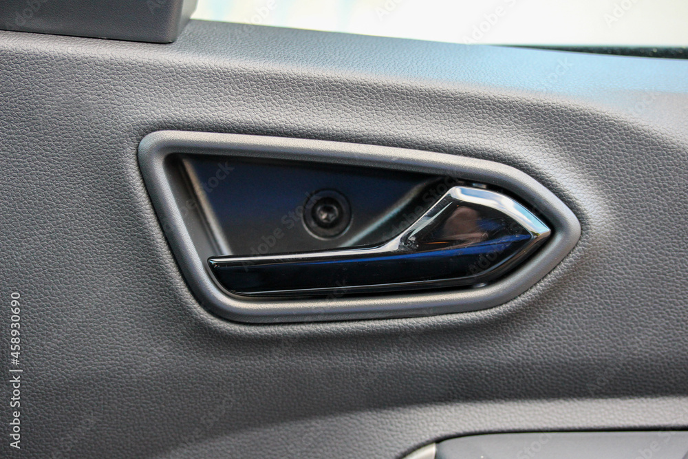 Black interior door handle in a budget vehicle