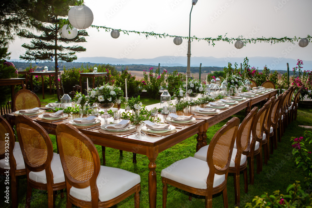 Wedding organization preparation restaurant and wedding planners.Chairs and honeymooners table decorated with candles, served with cutlery and crockery and covered with a table cloth. wedding area