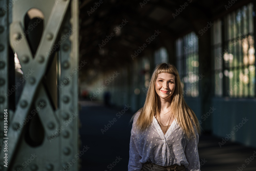 young beautiful woman at the train station against the background of high windows