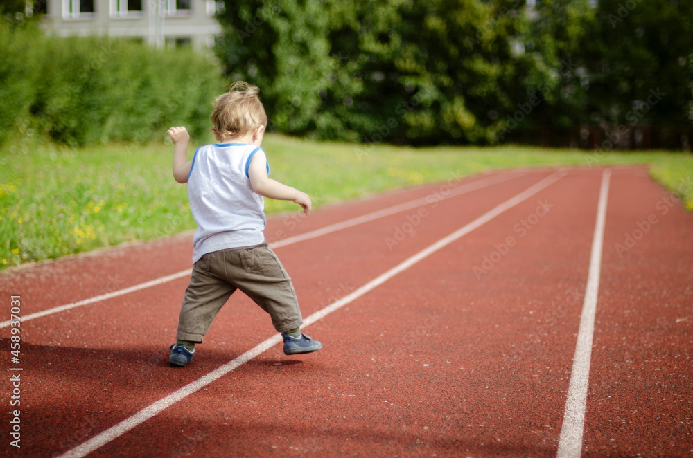 person running on the track,  one year baby walking on the running track in the school playground