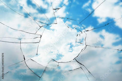 View through broken window on cloudy sky