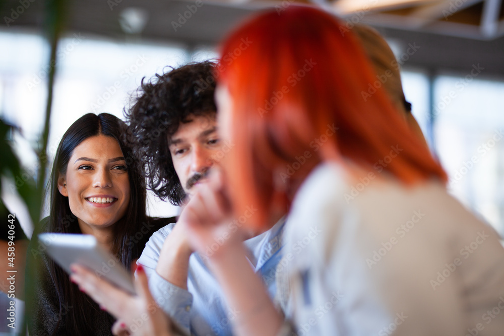 Fiends sitting at a cafe bar having a conversation looking at tablet. Positive face expressions..