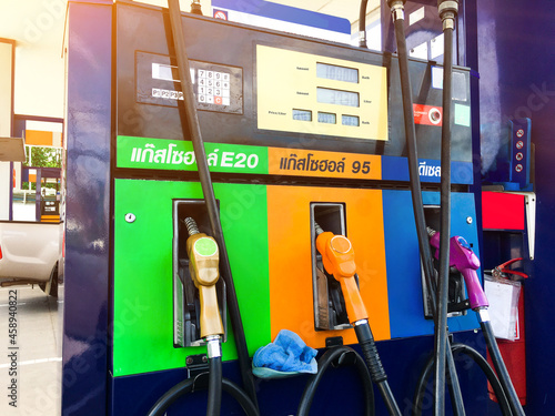 Fuel pumps machines and nozzles with text in Thai meaning at the green, the orange and the blue is gasohol