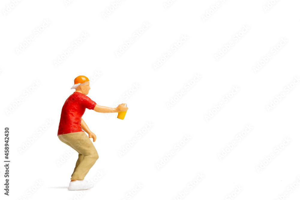 Miniature people Teenager spraying paint from can on white background and space for text Miniature people Teenager spraying paint from can on white background and space for text
