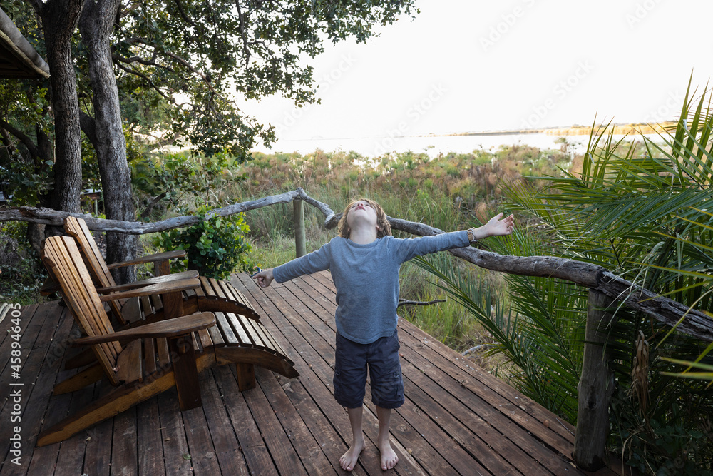 Young boy on a viewing terrace in a permanent camp in the Okavango Delta Young boy on a viewing terrace in a permanent camp in the Okavango Delta