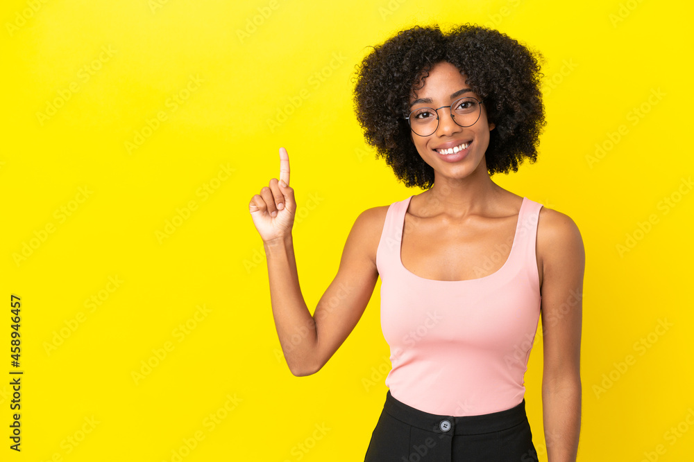 Young African American woman isolated on yellow background showing and lifting a finger in sign of the best