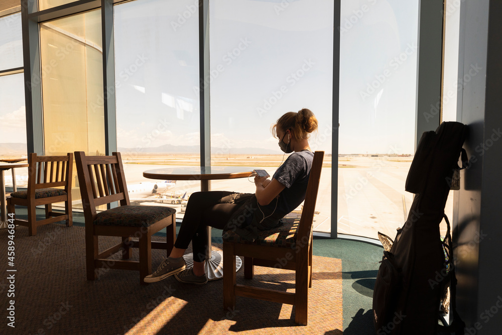 Teenage girl sitting waiting in an airport lounge, on her smart phone, Botswana. Teenage girl sitting waiting in an airport lounge, on her smart phone, Botswana.