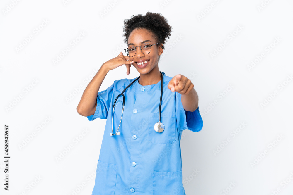 Young surgeon African American doctor woman isolated on white background making phone gesture and pointing front Young surgeon African American doctor woman isolated on white background making phone gesture and pointing front