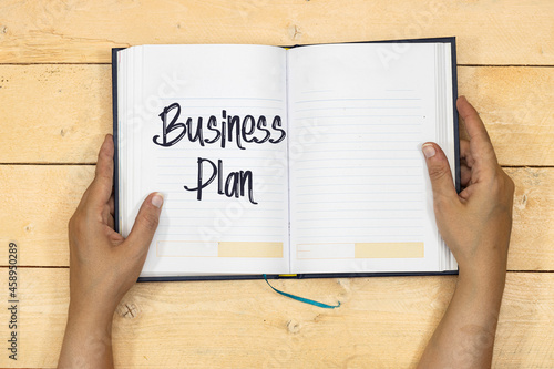 hands woman holding a notebook or agenda with Business Plan Growth Concept