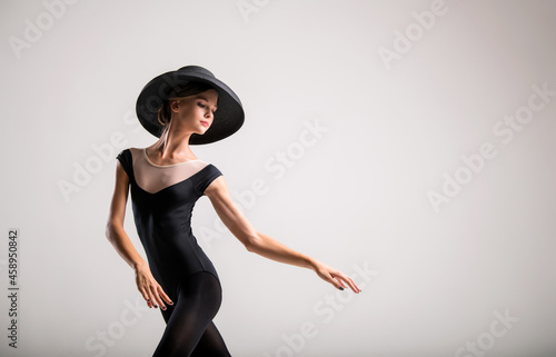 Romantic portrait of beautiful young girl on a light background in an elegant hat
