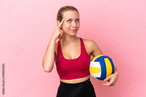 Young caucasian woman playing volleyball isolated on pink background having doubts and thinking