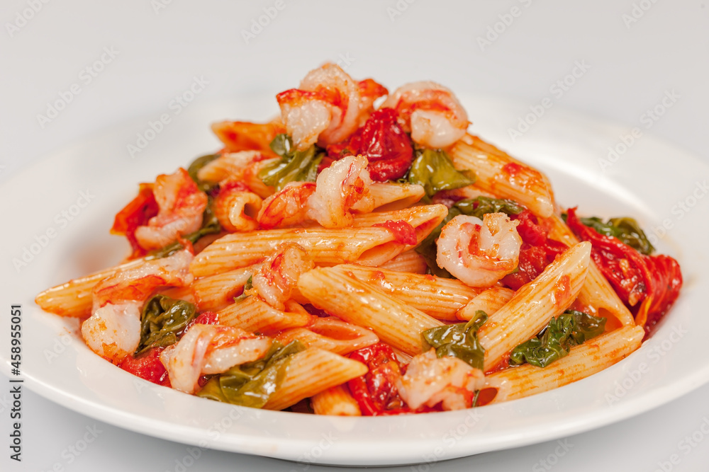Penne pasta with shrimps, tomato sauce, parsley and grated parmesan cheese Penne pasta with shrimps, tomato sauce, parsley and grated parmesan cheese