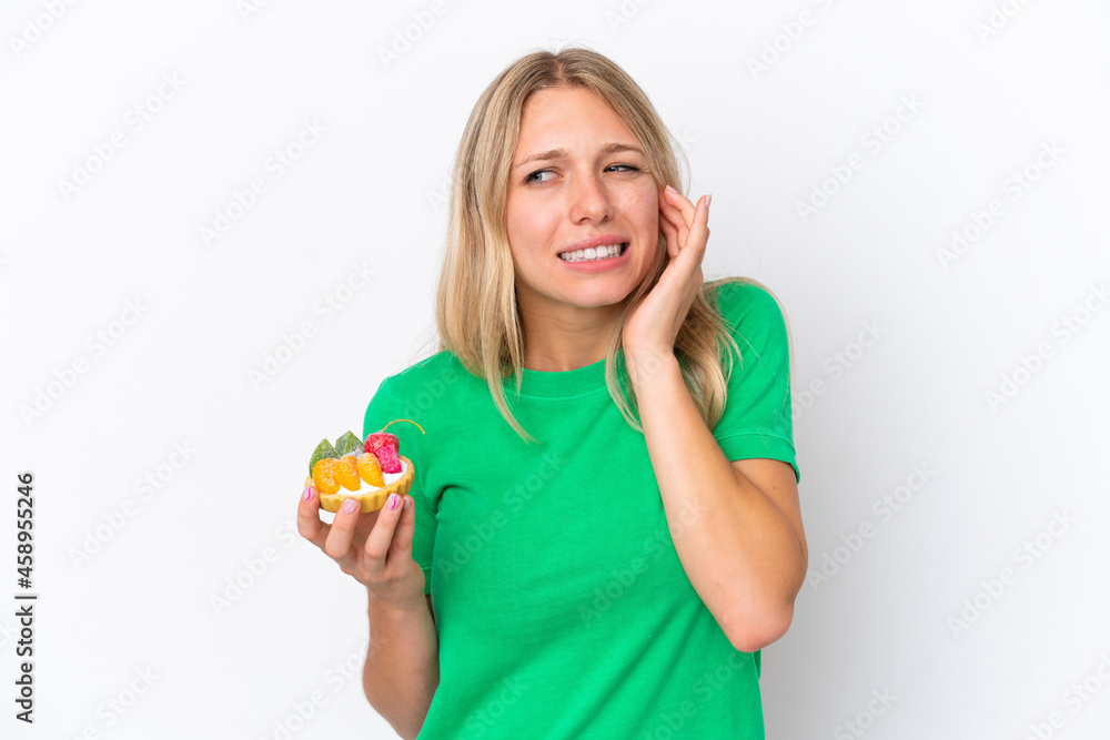 Young caucasian woman holding a tartlet isolated on white background frustrated and covering ears Young caucasian woman holding a tartlet isolated on white background frustrated and covering ears