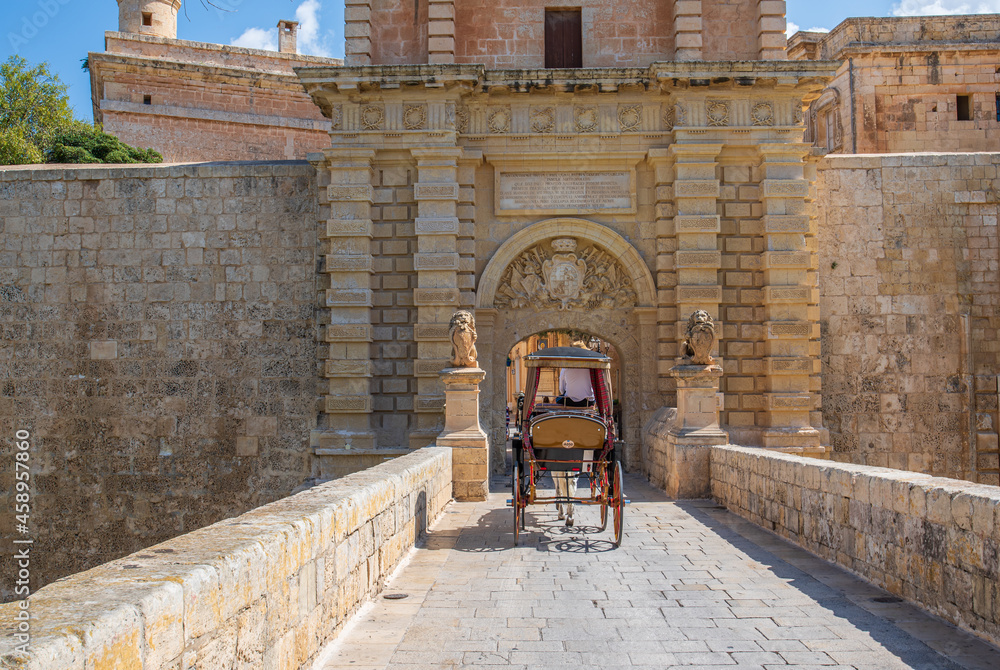 Mdina Malta  the gated main entrance with a horse drawn carriage going over the stone bridge