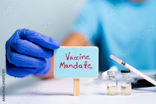 Фотография Concept of coronavirus or covid-19 vaccine mandate, showing with doctor hands wi