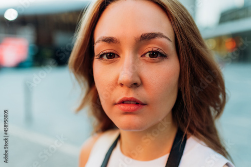 Headshot young caucasian woman posing outdoor looking camera powerful with confidence and attitude