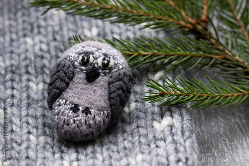 Handmade wool brooch on a sweater background. Selective focus.