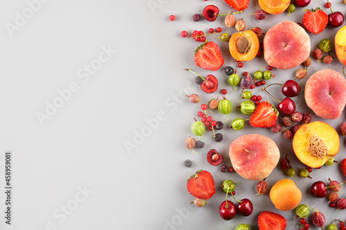 Multi-colored different fruits on a gray background. Place for text.