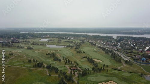 Aerial shot of golf fields and township near the river
